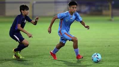 A Minerva Academy player, right, controls with the ball.