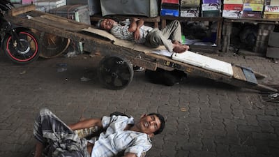 Porters take a nap while business is slow at Crawford Market. Subhash Sharma for The National