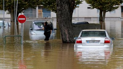 A man carries baguettes under his arm as he walks in high water. Reuters