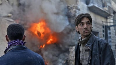 Civilians in Aleppo look on as a building erupts in flames after a government air strike. Unlike Russia, the West has no endgame in Syria. (EPA/Ali Mustafa)