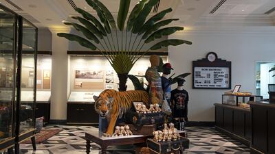 A stuffed tiger stands among merchandise displayed in the Raffles Boutique at the Raffles Hotel. Bloomberg