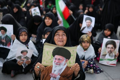 Iranian mourners hold images of Ayatollah Ali Khamenei and his son, Mojtaba, at the Imam Khomeini Grand Mosalla in Tehran. Reuters