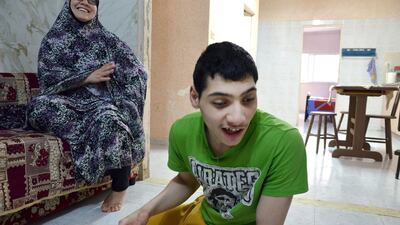 Mohammad, 15, is pictured with his mother Islam in the living room of their home in the West Bank refugee camp of Aida. Kate Shuttleworth for The National