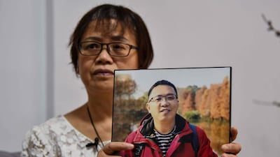 Zhong Hanneng displaying a portrait of her son Peng Yi who died from the coronavirus in the city of Wuhan, in China's central Hubei province. AFP
