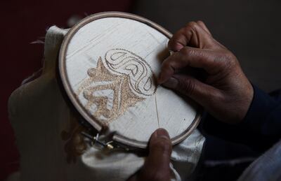 An Afghan tailor working on a cotton fabric piece at Zarif Design House in Kabul.
