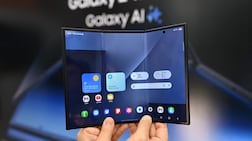 A visitor holds a Samsung Galaxy Z TriFold smartphone during a launch event at a Samsung store in Seoul on December 2, 2025. Samsung Electronics unveiled its first tri-fold phone on December 2, as the conglomerate rushes to show it can keep pace with rivals in generative AI. (Photo by Jung Yeon-je / AFP)