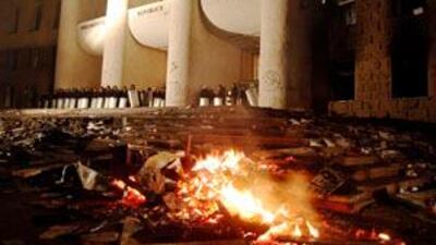 Police guard the looted and burning parliament building in Chisinau today.