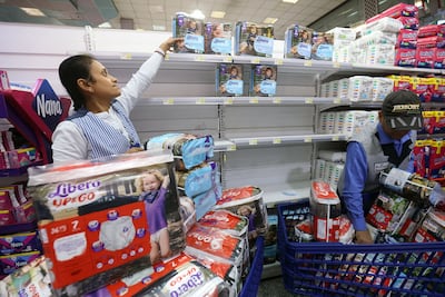 Supermarket employees remove Swedish products from shelves in Kuwait City on July 1, 2023. Yasser Al-Zayyat / AFP