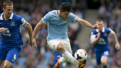 Manchester City's Sergio Aguero, centre, keeps the ball from Everton's Philip Jagielka. Jon Super / AP Photo