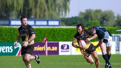 Paul Griffen, centre, escapes the J9 defense to score for Gulf Legends on Day 2 at the Dubai Rugby Sevens. Victor Besa for The National