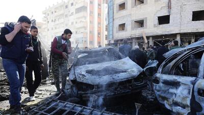 Syrian pro-government forces and residents gather at the site of suicide bombings in the area of a revered Shiite shrine in the town of Sayyida Zeinab, on the outskirts of the capital Damascus, on January 31, 2016. ISIL claimed responsibility for the bombings that killed at least 45 people. / AFP / LOUAI BESHARA