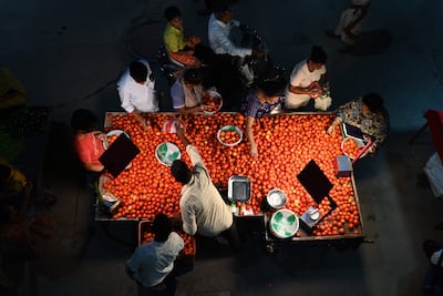 Customers buy vegetables at a weekly night market in Hyderabad in May, before prices shot up. AFP