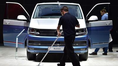 A worker cleans the floor around a Volkswagen multivan on display during the German car maker's annual general meeting in Hanover. The emissions cheating scandal has plunged the group into an unprecedented crisis. John MacDougal/AFP