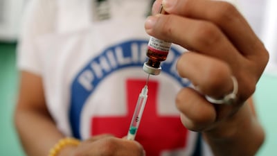 A Philippine Red Cross worker prepares a measles vaccine at an immunisation programme in Manila. EPA