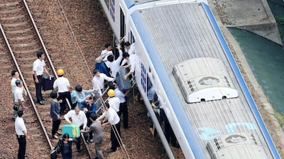 Passengers descend from a train on the track after train service was suspended to check for damage following an earthquake in Takatsuki city, Osaka. AP Photo