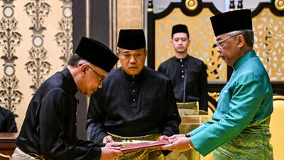 Malaysia's King Sultan Abdullah Sultan Ahmad Shah, right, and newly appointed Prime Minister Anwar Ibrahim, left, take part in the swearing-in ceremony at the National Palace in Kuala Lumpur, Malaysia. AP