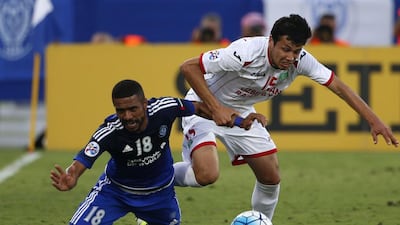 UAE's Al-Nasr club player Ahmed Al-Yassi (L) and Uzbekistan's Lokomotiv player Sardor Mirzaev (R) falls to the ground as they vie for the ball during their Asian Champions League (AFC) group A football match at the Rashid Al-Maktoum Stadium in Dubai on April 20, 2016. / AFP / KARIM SAHIB
