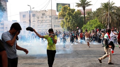 Iraqi protesters run for cover amid tear gas fired by policemen during a demonstration at Tahrir Square, central Baghdad. EPA