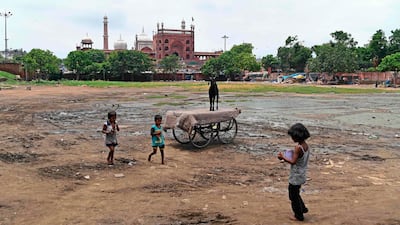 A goat stands on a handcart as children play in a deserted ground in the old quarter of New Delhi that is usually used as a temporary cattle market ahead of Eid Al Adha. AFP