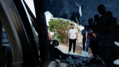 People stand next to a damaged vehicle after a raid by Israeli troops in Jenin, occupied West Bank on Friday. Reuters