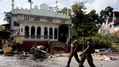 Soldiers from Sri Lanka's Special Task Force walk past a mosque damaged in violence between Buddhists and Muslims the central district of Kandy on March 8, 2018. Dinuka Liyanawatte / Reuters