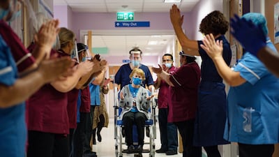 Margaret Keenan, 91, is cheered by staff after becoming the first person in the UK to receive a coronavirus vaccination. Getty Images