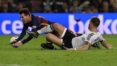 Lionel Messi vies with Valencia defender Shkodran Mustafi. Lluis Gene / AFP