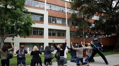 A police officer conducts a search on people at the University of California, Los Angeles (UCLA) campus after it was placed on lockdown following a murder-suicide shooting on Wednesday. Patrick T Fallon/Reuters