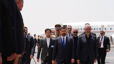 Iran's Finance Minister Seyed Ali Madanizadeh, right, receives Iraq's Prime Minister Ali Al Zaidi, centre, at the airport in Tehran. AFP