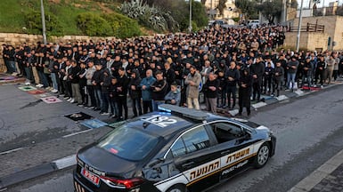 An Israeli police vehicle moves past Muslim worshippers gathering outside the Jerusalem old city walls on March 20. AFP