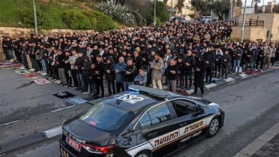 An Israeli police vehicle moves past Muslim worshippers gathering outside the Jerusalem old city walls on March 20. AFP