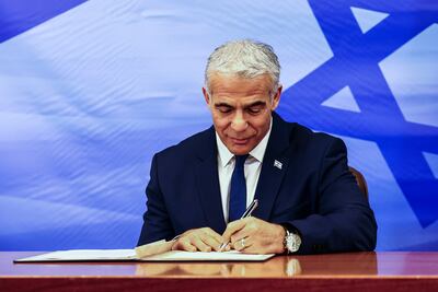 Israeli Prime Minister Yair Lapid signs the deal setting a maritime border between Israel and Lebanon. AP