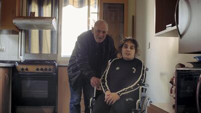 Ms Hajjar poses with her father, who cares for her, in her new flat. Adib Chowdhury for The National