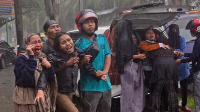People cry out as the body of a relative is retrieved from the ruin of a building at an area affected by an earthquake in Mamuju, West Sulawesi, Indonesia on January 15. Yusuf Wahil / AP Photo