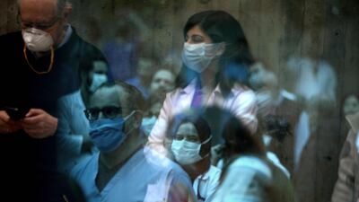 Medical staff at the Saint George Hospital University Medical Centre in charge of Covid-19 coronavirus patients reflections off a window as they listen to music played by a band thanking them for their efforts during the novel coronavirus pandemic. AFP