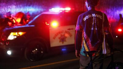 A protester looks on at a group of police officers after demonstrators ran onto Highway 580 during a demonstration following the grand jury decision in the Ferguson, Missouri shooting of Michael Brown, in Oakland, California in November. Stephen Lam / Reuters