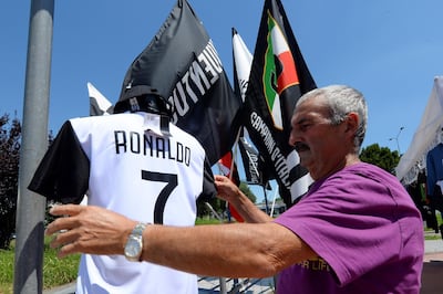 A vendor adjusts a Juventus jersey with the name of Cristiano Ronaldo in his shop in Turin, Italy on July 7. The Real Madrid forward has been linked with a €100 million move to the Serie A club. Reuters