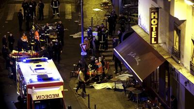 Rescue service personnel tend to the injured next to covered bodies outside a Paris restaurant attacked by gunmen on November 13, 2015. Philippe Wojazer / Reuters