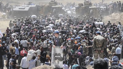 Syrian refugees wait for transportation after crossing into Turkey from the Syrian town of Tal Abyad. AFP Photo