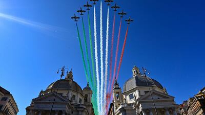 The Italian Air Force acrobatic unit Frecce Tricolori perform over the Basilica di Santa Maria in Montesanto, left, and the church di Santa Maria dei Miracoli at Piazza del Popolo in Rome as part of Republic Day ceremonies, as the country eases its lockdown aimed at curbing the spread of the coronavirus. AFP