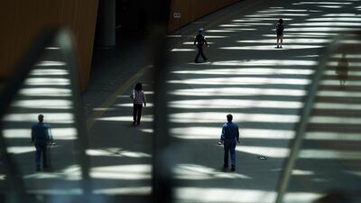 People walk in shade of a building in Tokyo. AP Photo