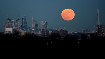 The moon rises over the London skyline last month. KIrsty O'Connor / PA via AP