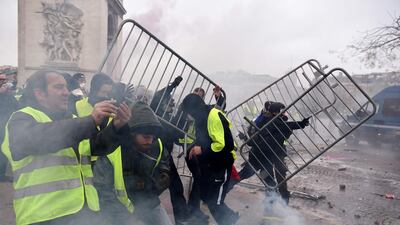 Demonstrators throws metal barriers during a protest of Yellow vests against rising oil prices and living costs on the Champs Elysees avenue in Paris on December 1, 2018. AFP