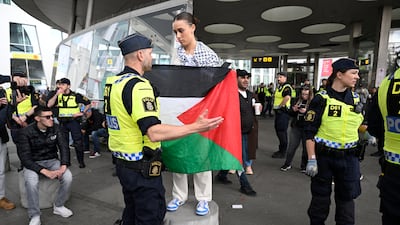 A police officer talks to a demonstrator at a pro-Palestine rally against the participation of Israel in the 68th Eurovision Song Contest in Malmo. EPA