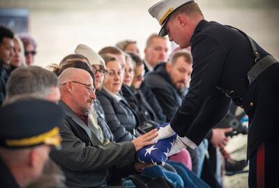 A US Marine presents Jim McCollum with a folded American flag during memorial services for his son, who was was among 13 US soldiers killed in the suicide bombing at Kabul airport on August 26, 2021. AP