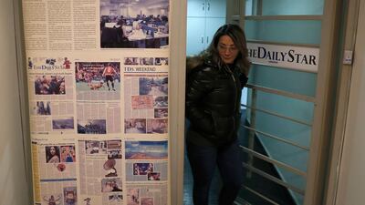 An employee of The Daily Star newspaper opens the main door of the newspaper office, in Beirut, Lebanon. Lebanon's only English-language newspaper has announced that it's temporarily suspending its print edition. AP Photo