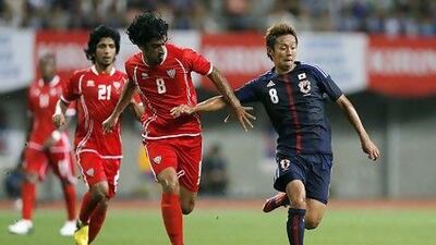 UAE's Hamdan Al Kamali, centre, battles Hiroshi Kiyotake, right.