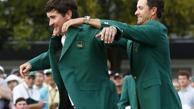 Defending Masters Champion Adam Scott of Australia, right, helps Bubba Watson of the US into his second green jacket after winning the 2014 Masters Tournament at the Augusta National Golf Club in Augusta, Georgia, USA, 13 April 2014. EPA/ERIK S. LESSER