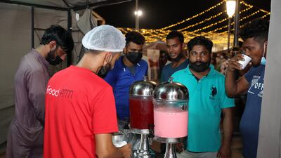 Labourers queue for food and drink.