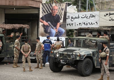 Lebanese army members near a poster of Fadi Bejjani, who died during exchange of fire at the area where a truck was overturned the previous night, in Kahaleh, on August 10. Reuters